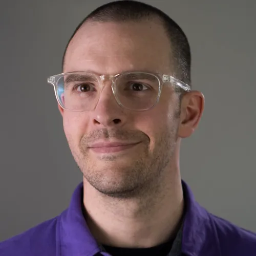 Headshot photo of Sean G. Wright in purple shirt with a gray background